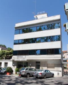 un edificio con auto parcheggiate di fronte di Hotel Aurora a Mestre