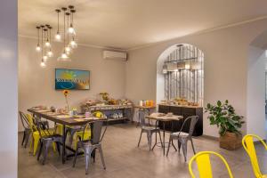 uma sala de jantar com mesas e cadeiras amarelas em Urban Garden Hotel em Roma