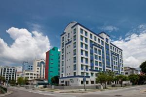 a tall white building on the side of a street at YaJu Hotel in Singapore