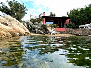 a house sitting on the shore of a body of water at Villa Mica in La Maddalena