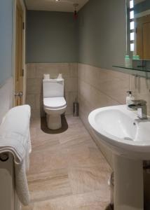 uma casa de banho com um lavatório branco e um WC. em The Red Pump Inn em Clitheroe