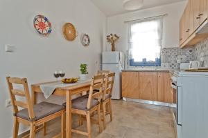 a kitchen with a table and chairs and a refrigerator at Alisachni Villas in Lefkos Karpathou