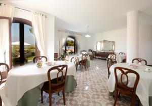 a dining room with tables and chairs and a mirror at Il Paradiso Di Hyele in Ascea