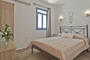 a bedroom with a bed and a window and a table at Alisachni Villas in Lefkos Karpathou