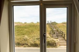 a door with a view of a staircase through a window at The Sail Loft in Southwold
