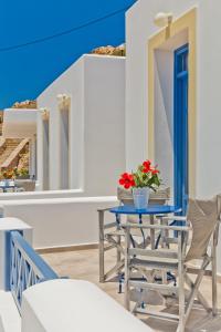 a table and chairs on a balcony with blue ceilings at Alisachni Villas in Lefkos Karpathou