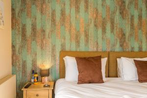 a bedroom with a bed and a green wall at The Sail Loft in Southwold