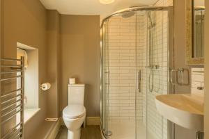 a bathroom with a toilet and a shower and a sink at The Sail Loft in Southwold