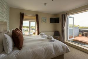 a bedroom with a bed and a large window at The Sail Loft in Southwold