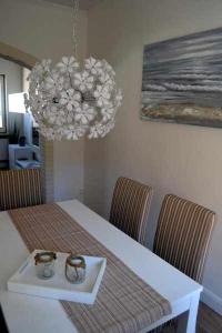 a dining room with a white table and a chandelier at Ferienhaus-Am-Strand in Eckernförde