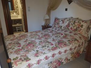 una camera da letto con un letto con copriletto floreale di Georgia Old Town Apartments a Città di Rodi