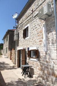 una mesa de picnic sentada fuera de un edificio de piedra en Vacation home Ania, en Prvić Luka