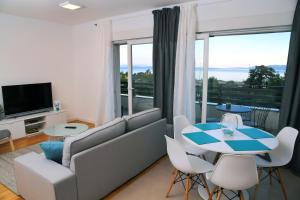 a living room with a couch and a table and chairs at Apartmani Valis in Matulji