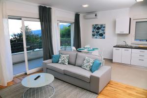 a living room with a couch and a table at Apartmani Valis in Matulji
