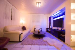 a living room with a couch and a tv at Locastudio - Grenadine in Sainte-Anne