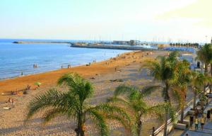 una spiaggia con palme e una folla di persone di Murri Apartment a Ragusa