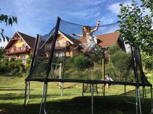 a young girl jumping on a trampoline at Apartments Lipno Serafin in Lipno nad Vltavou