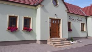 シャトフにあるPenzion u Šimečkůの茶色の扉と花の白い建物