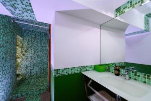 baño con azulejos verdes y blancos y espejo en Diemme Studio, en Salerno