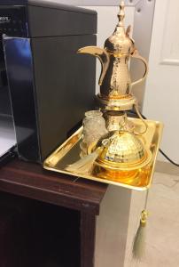 a serving tray with a tea kettle on a table at Al Sondos Furnished Apartments in Abha