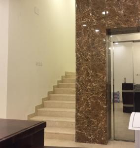 a set of stairs in a room with a marble wall at Al Sondos Furnished Apartments in Abha