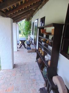 un patio con una mesa y estanterías en un edificio en Rigó Vendégház, en Őriszentpéter