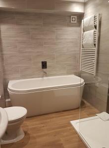 Laxton的住宿－德福蔻特旅館，带浴缸、卫生间和盥洗盆的浴室