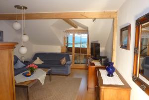 ein Wohnzimmer mit einem Sofa und einem TV in der Unterkunft Ferienwohnungen Anneliese&Fritz Wagerer in Rimbach