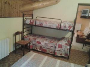 a bedroom with two bunk beds and a table at Alloggi Il Rododendro in Bagni di Vinadio