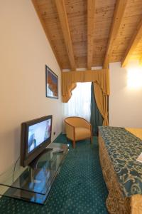 a bedroom with a bed and a television at Hotel Capri in Bardolino