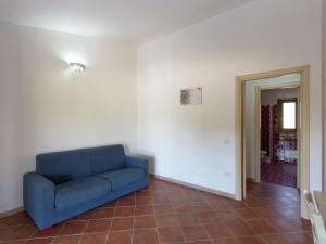 Li ValcaggiにあるApartment in Trinit d Agultu e Vignolaのタイルフロアの客室で、青いソファが備わります。