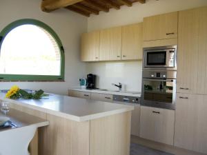eine Küche mit einer Spüle und einer Mikrowelle in der Unterkunft Belvilla by OYO Sparsa Girasole in Cortona