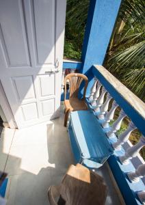 a porch with a chair and a glass table at Veeniola Holiday Home in Cavelossim