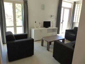 a living room with two chairs and a coffee table at Chic Apartment in Parghelia Italy in Parghelia