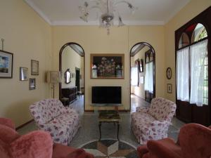 a living room with two chairs and a television at Belvilla by OYO Villa Fiorita Uno in Romano D'Ezzelino