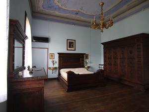 1 dormitorio con cama de madera y lámpara de araña en Belvilla by OYO Villa Fiorita Uno en Romano D'Ezzelino