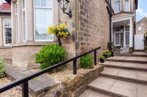 a home with a black railing and stairs in front of a building at Ashwood House Guest House in Harrogate