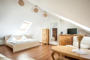 a white room with a bed and a tv at Laguna Self Check-in in Nida