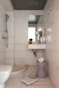 a bathroom with a sink and a toilet and a mirror at Dorian Inn - Sure Hotel Collection by Best Western in Athens