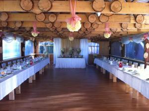 a long row of tables in a room with wooden ceilings at Europe Guesthouse in Narva