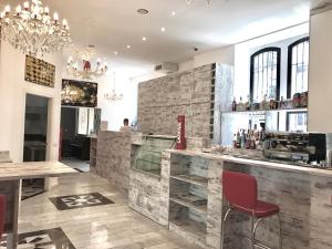 un restaurante con un bar con sillas rojas en New Generation Hostel Milan Center Navigli en Milán