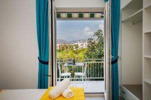 a room with a door open to a balcony with a view at SorrentoLife in Sorrento