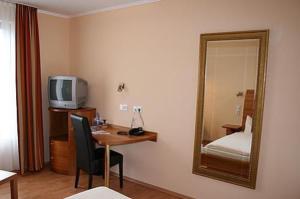 a hotel room with a desk and a mirror at Hotel Wadegotia in Wadgassen