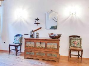 ブレッサノーネにあるBelvilla by OYO Rosalpinaの椅子2脚、ドレッサー、鏡が備わるお部屋