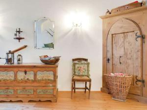 ブレッサノーネにあるBelvilla by OYO Rosalpinaのドレッサー、椅子、鏡が備わる客室です。