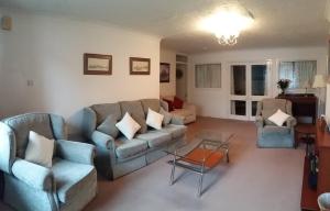 a living room with a couch and two chairs and a table at Clarence Road Apartment in Gosport
