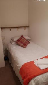 a bedroom with a white bed with a red pillow at Clarence Road Apartment in Gosport