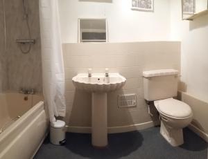 ein Badezimmer mit einem Waschbecken, einem WC und einer Badewanne in der Unterkunft Clarence Road Apartment in Gosport