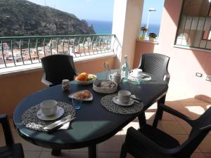 a dining table with a view of the beach at Buggerru a Mare Residence in Buggerru