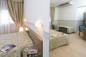Postel nebo postele na pokoji v ubytování Hotel Garibaldi